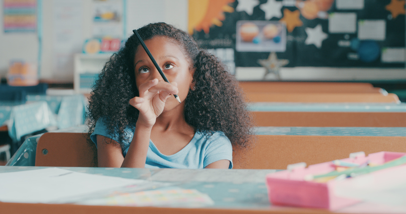 Girl in classroom distracted by a pencil