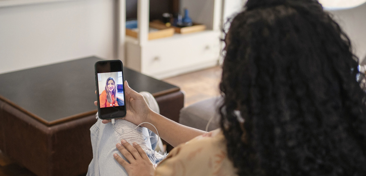 African Amican young woman talking to psychologist in video conference